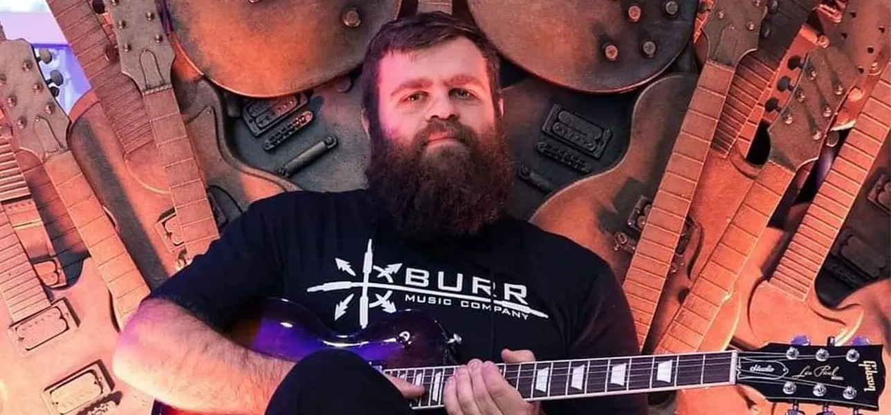 Evan Bernard, co-owner of Jamtown, the best recording studio in philadelphia, posing with a guitar